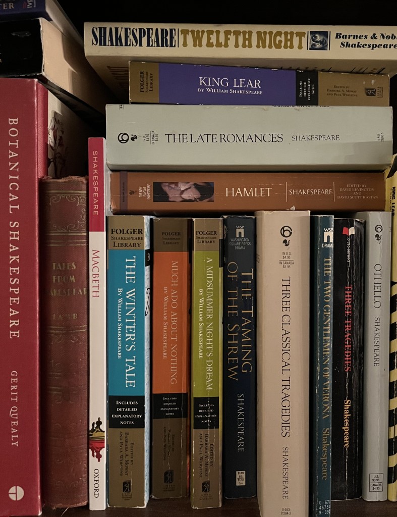 A bookshelf with Shakespeare plays filling the image and several more stacked on top of the shelved books.